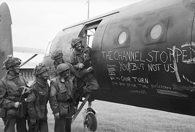 Paracaidistas británicos antes de subir a los transportes. En el avión pone "El Canal os detuvo, pero a nosotros no" - Imagen de dominio público